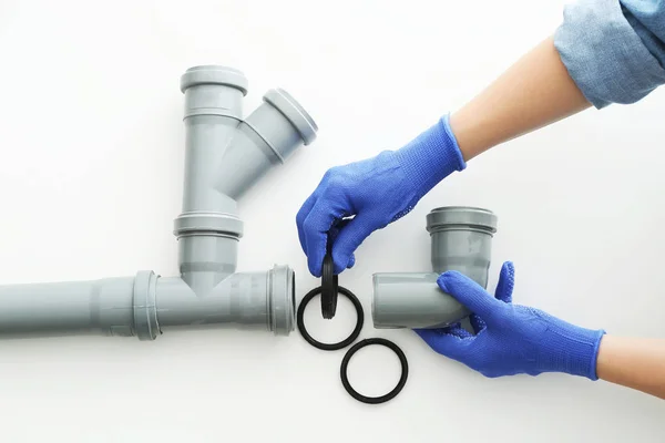 Plumber working with drain pipe on white background — Stock Photo, Image