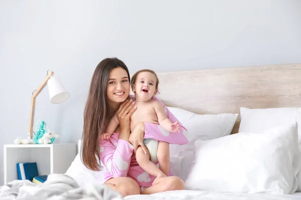 Happy mother with adorable baby boy sitting on bed at home — Stock Photo, Image