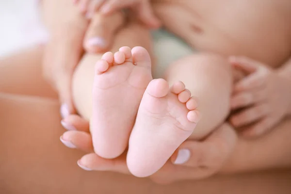 Mother holding tiny feet of little baby, closeup — Stock Photo, Image
