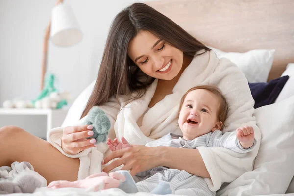 Madre feliz con adorable bebé niño en la cama en casa —  Fotos de Stock