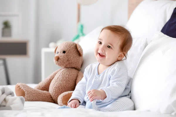 Retrato de menino adorável com brinquedo na cama em casa — Fotografia de Stock