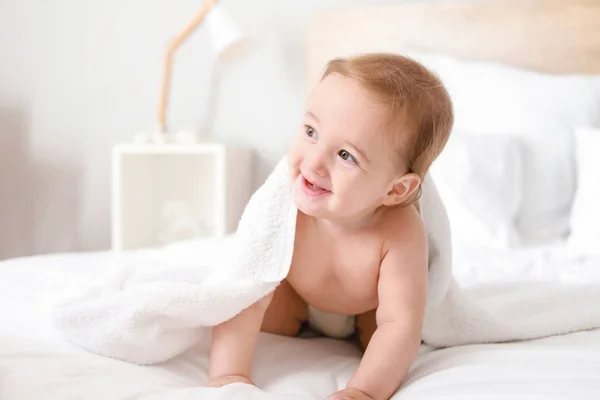 Porträt eines entzückenden Jungen unter dem Handtuch auf dem Bett — Stockfoto