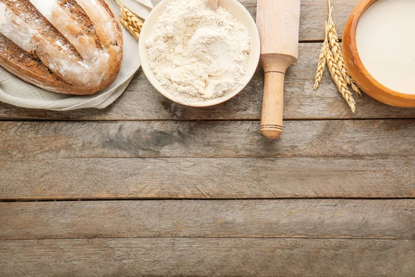 Mehl mit Brot, Milch und Nudelholz auf Holzgrund — Stockfoto