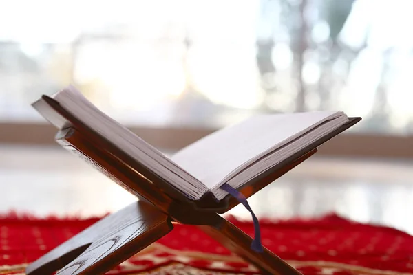 Rehal z otwartym Koran na muzułmańskich mat modlitwy w pomieszczeniu — Zdjęcie stockowe