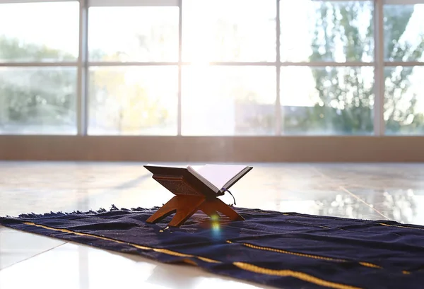 Rehal med öppna Koranen på muslimsk bön matta inomhus — Stockfoto