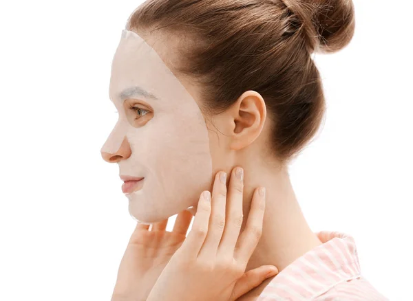 Mujer joven con mascarilla facial de hoja sobre fondo blanco —  Fotos de Stock