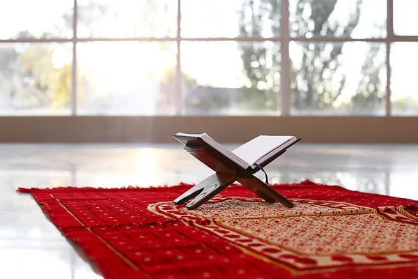 Rehal with open Koran on Muslim prayer mat indoors — Stock Photo, Image