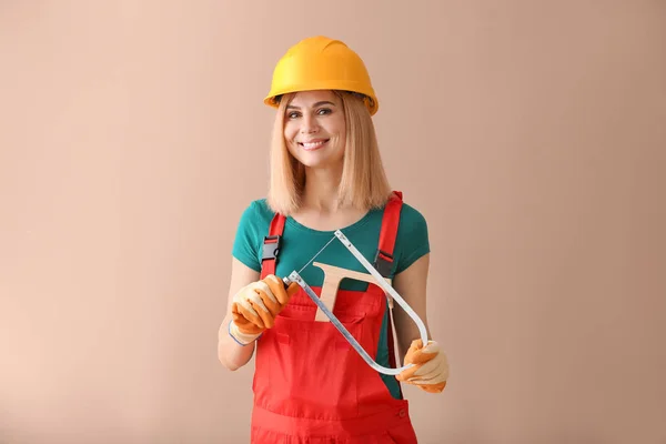 Female carpenter on color background — Stock Photo, Image