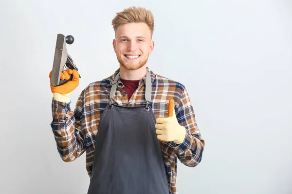 Manlig snickare som visar tummen upp gest på grå bakgrund — Stockfoto