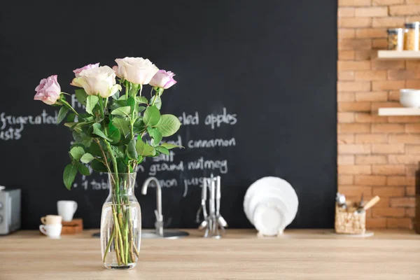 Vas med vackra blommor på bord i köket — Stockfoto