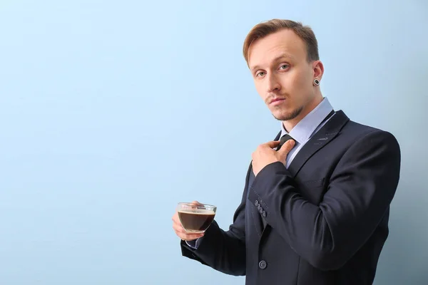 Stilig affärsman med kopp kaffe på ljus bakgrund — Stockfoto