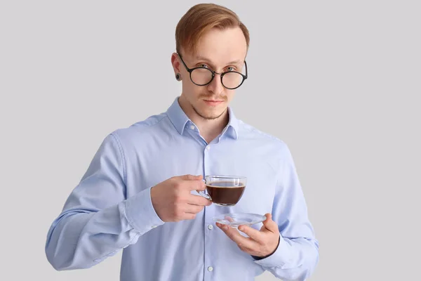 Bello uomo d'affari con tazza di caffè su sfondo chiaro — Foto Stock