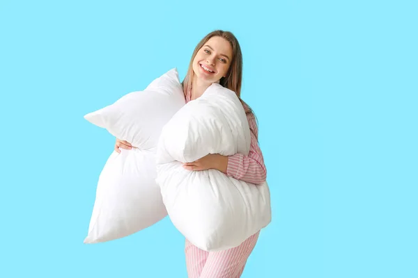 Young woman with pillows on color background — Stock Photo, Image