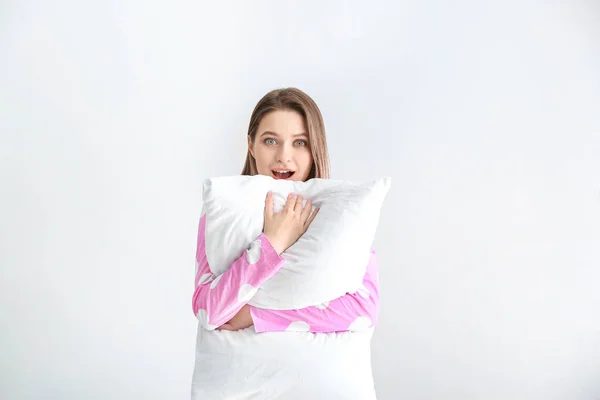 Mulher excitada com travesseiro no fundo branco — Fotografia de Stock