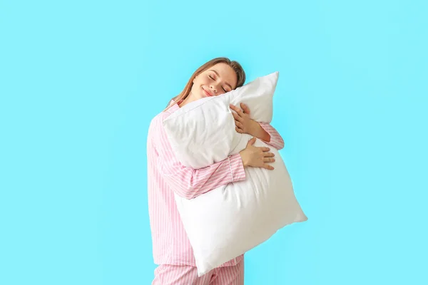 Young woman with pillow on color background — Stock Photo, Image