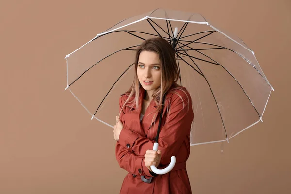 Mujer joven y fría con paraguas sobre fondo de color — Foto de Stock