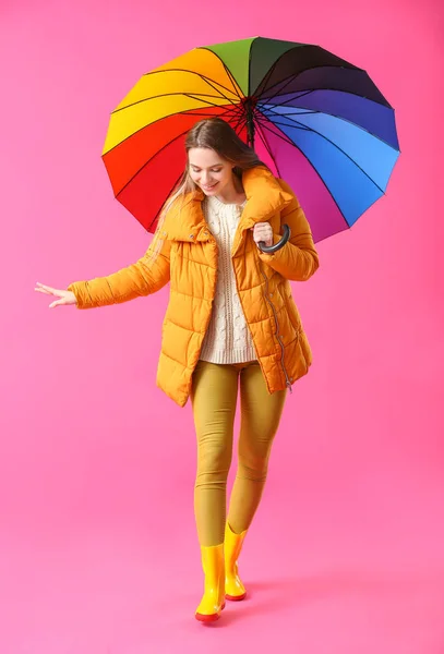 Beautiful young woman with umbrella on color background — Stock Photo, Image