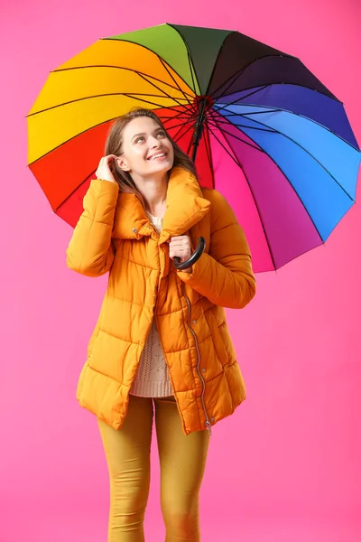 Beautiful young woman with umbrella on color background — Stock Photo, Image