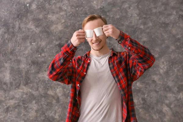 Homem engraçado com xícaras de café no fundo grunge — Fotografia de Stock