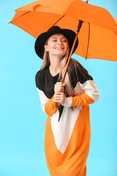 Красивая молодая женщина с зонтиком на цветном фоне — стоковое фото