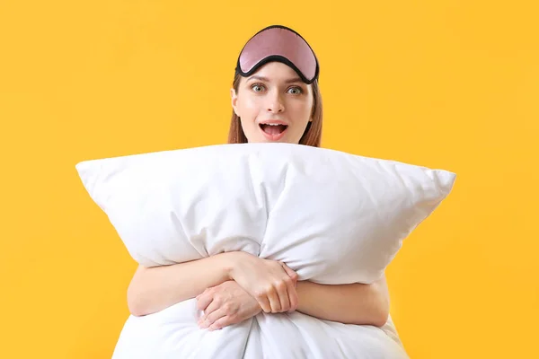 Surprised woman with pillow and sleep mask on color background — Stock Photo, Image