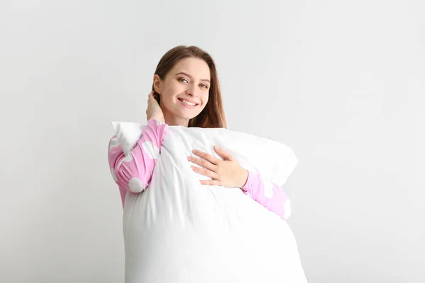 Молодая женщина с подушкой на белом фоне — стоковое фото