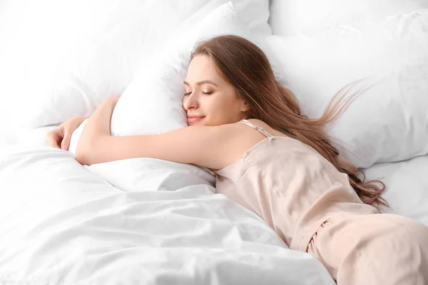 Όμορφη νεαρή γυναίκα κοιμάται στο κρεβάτι — Φωτογραφία Αρχείου