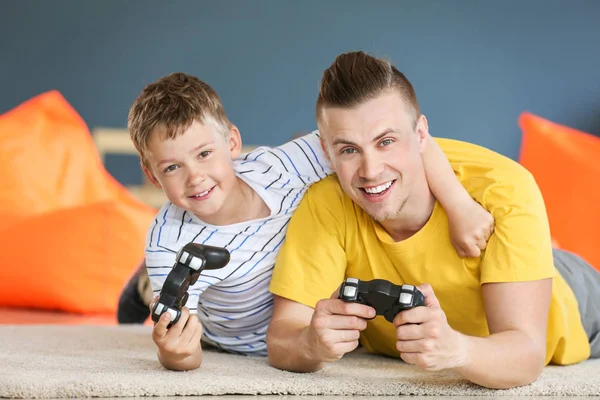 Retrato de pai e filho jogando videogame em casa — Fotografia de Stock