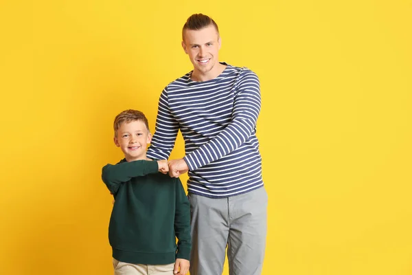 Portret szczęśliwego ojca i syna na kolorowym tle — Zdjęcie stockowe