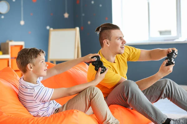 Retrato de padre e hijo jugando videojuegos en casa —  Fotos de Stock