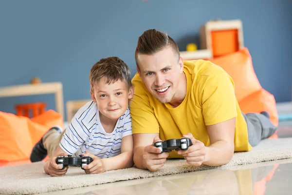 घरी व्हिडिओ गेम खेळत वडील आणि मुलाचे पोर्ट्रेट — स्टॉक फोटो, इमेज