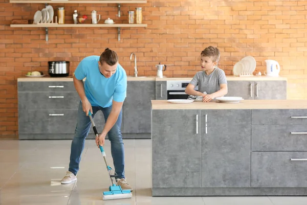 Father and son cleaning kitchen together — Stock Photo, Image
