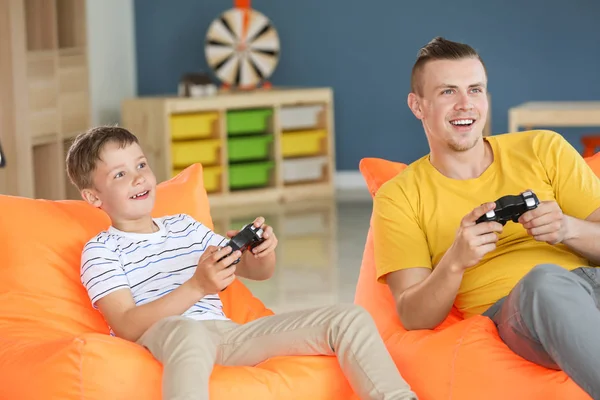 Retrato de pai e filho jogando videogame em casa — Fotografia de Stock