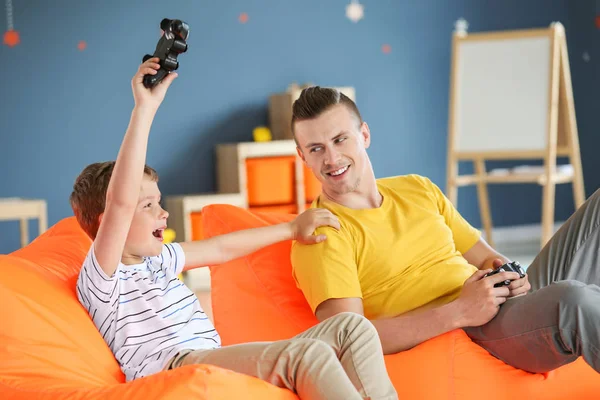 Retrato de padre e hijo jugando videojuegos en casa — Foto de Stock