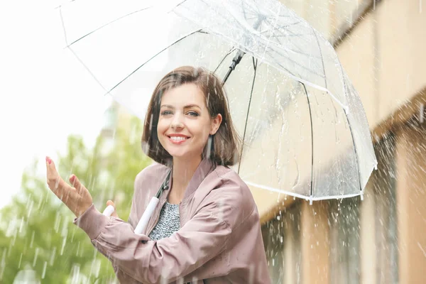 Schöne junge Frau mit Regenschirm im Freien an einem regnerischen Tag — Stockfoto