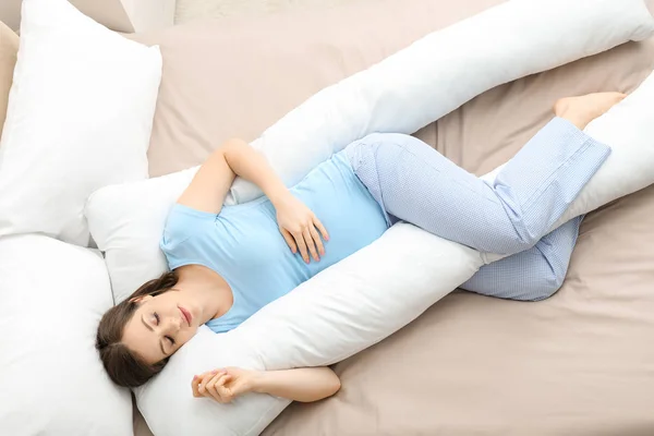 Unga gravid kvinna sover på moderskap kudde hemma — Stockfoto