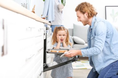 Genç adam ve küçük kızı evde lezzetli kurabiye pişirme