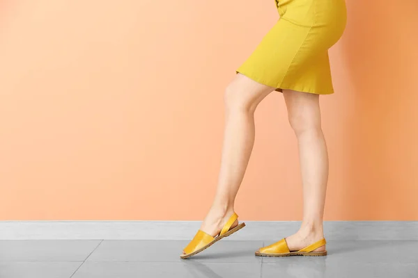 Mujer joven en zapatos elegantes contra la pared de color — Foto de Stock