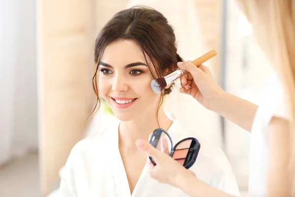 Professional makeup artist working with young bride at home — Stock Photo, Image