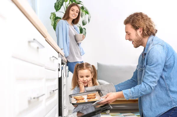 年轻人和他的小女儿在家里烤美味的饼干 — 图库照片