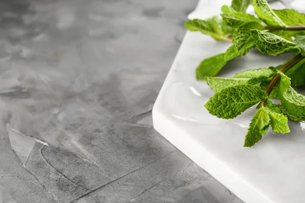 Board with fresh mint on grey background, closeup — Stock Photo, Image
