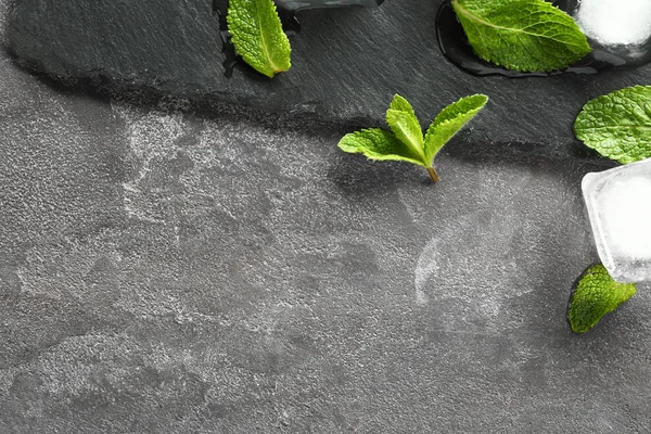Slate plate, mint and ice cubes on grey background — Stock Photo, Image