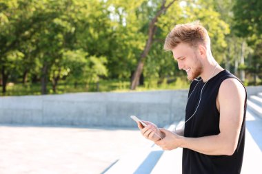 Sportif genç adam nabzını dışarıda kontrol ediyor