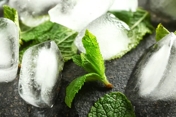 Cubos de gelo e hortelã fresca sobre fundo cinza, close-up — Fotografia de Stock