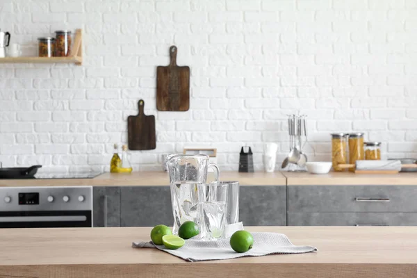 Kruik en glazen met zoet water en kalk op tafel in de keuken — Stockfoto