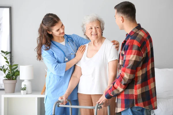 Mujer mayor con su nieto y cuidador en un hogar de ancianos — Foto de Stock