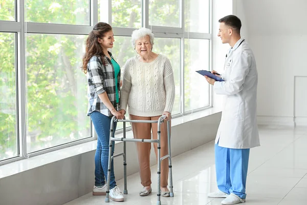 Старшая женщина с внучкой и доктором в больнице — стоковое фото