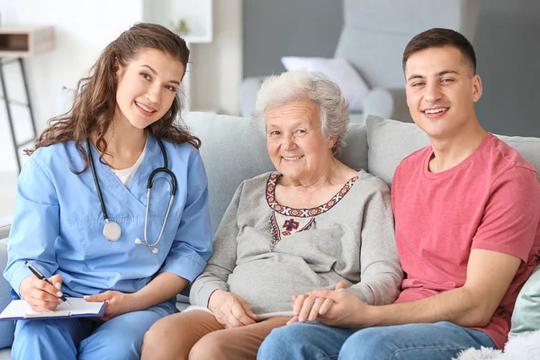 Caregiver visiting senior woman at home — Stock Photo, Image