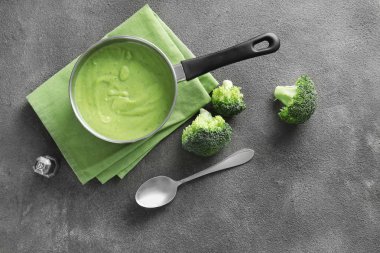 Gri arka planda lezzetli brokoli krema çorbası ile tencere