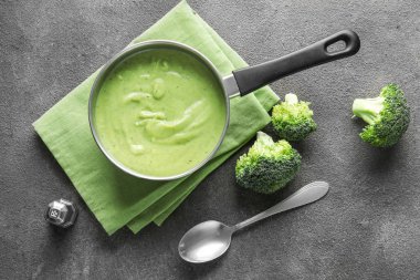 Gri arka planda lezzetli brokoli krema çorbası ile tencere